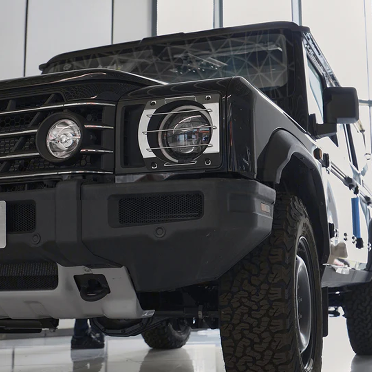 INEOS Grenadier headlight guards installed, showing black aluminium design that protects against debris and minor impacts.