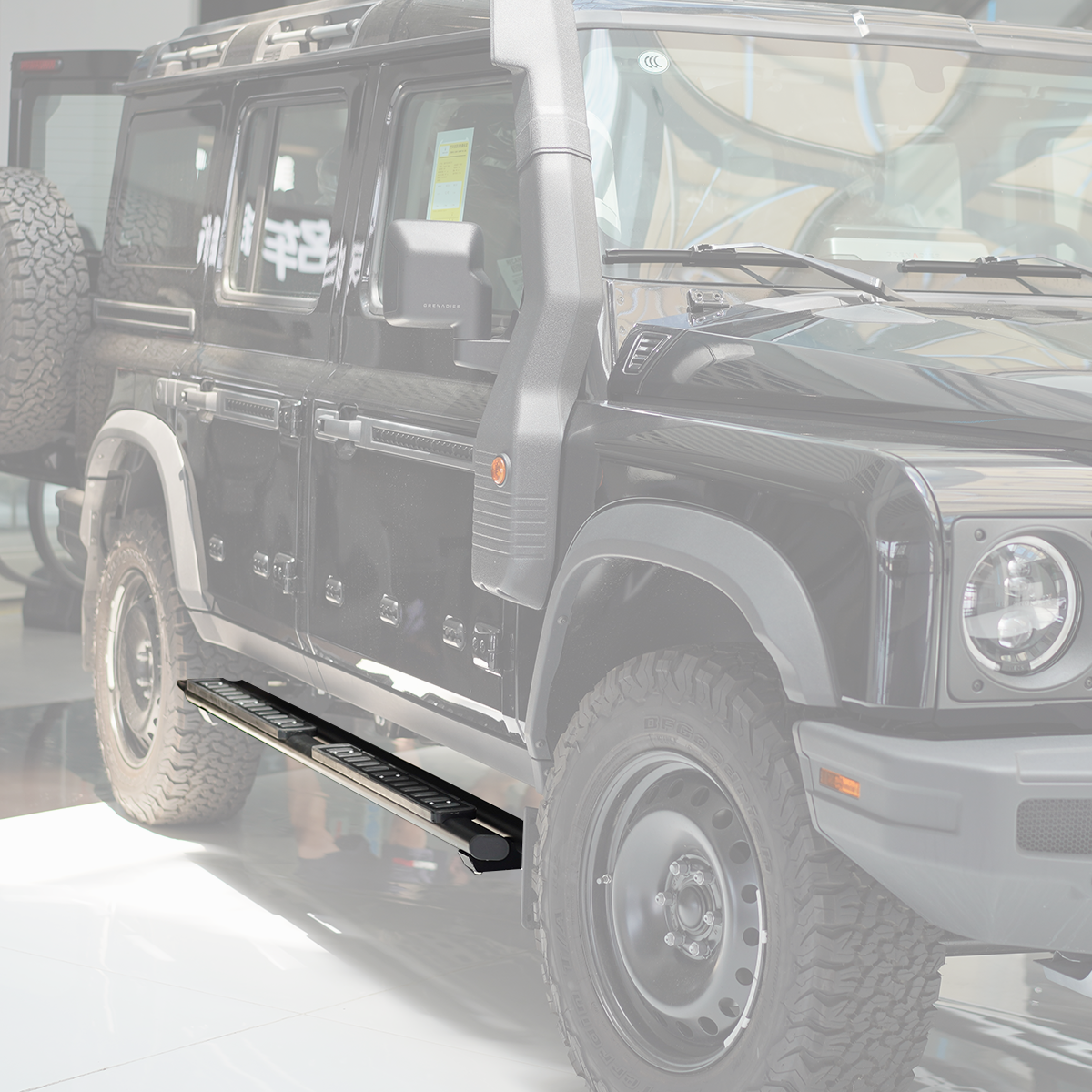 plomor-Dual-An image showing the Dual-Tube Fixed Side Steps installed on the side of an INEOS Grenadier. The steps are made from black powder-coated aluminium alloy and clearly show the double-bar structure and integrated anti-slip step pads.