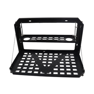 Close-up of the PLOMOR Grenadier Folding Table, showing precision laser-cut steel, MOLLE-compatible mounting slots, and integrated cup/bottle cut-outs.