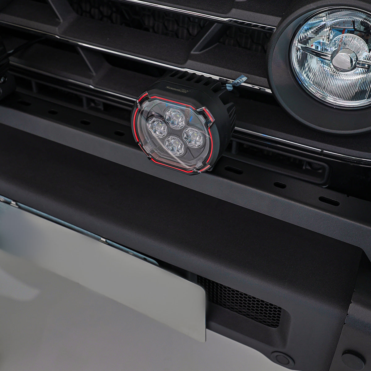 PLOMOR aluminium and steel front bumper light mount bracket for Ineos Grenadier. Gloss black finish, custom-fit for two spotlights or one LED light bar.