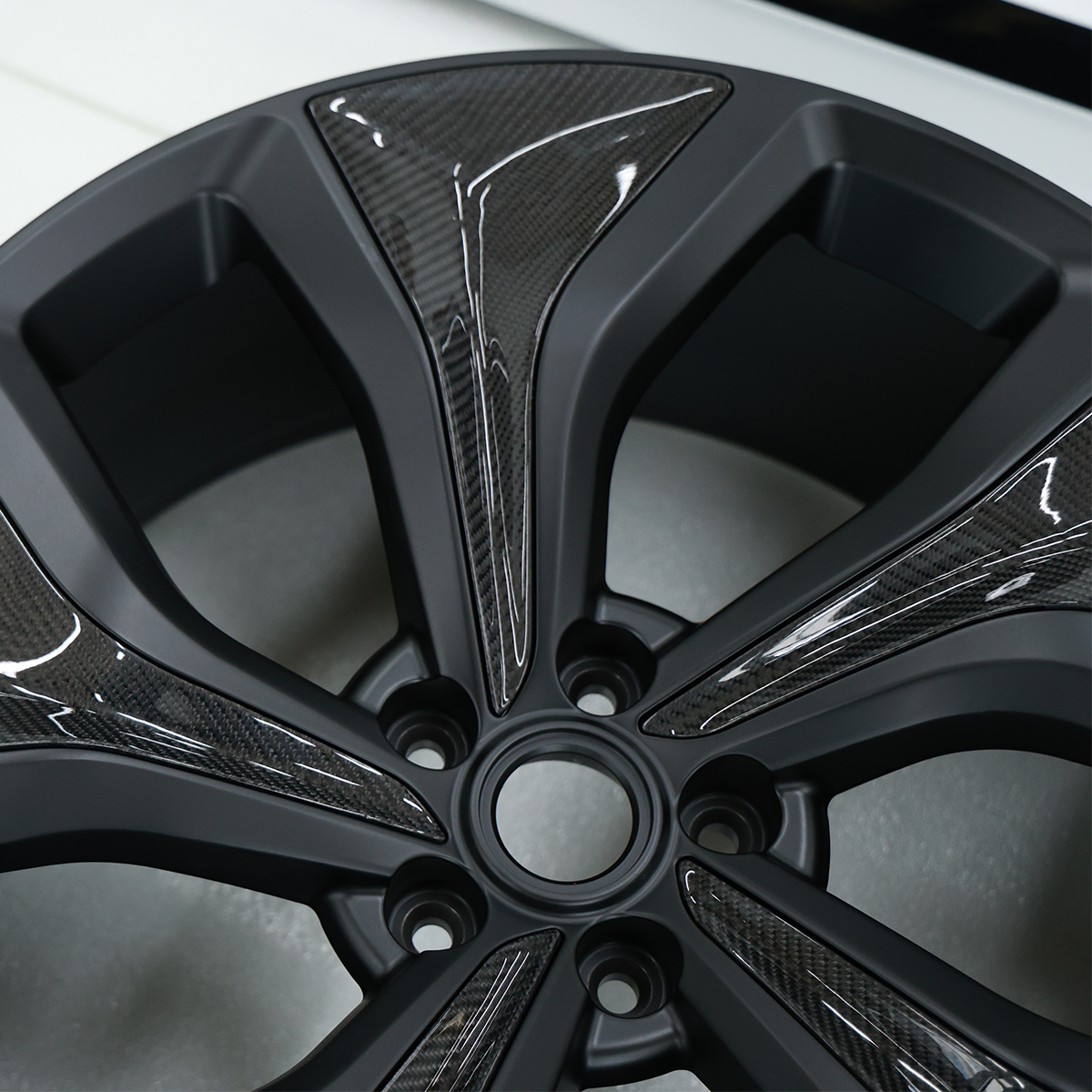 Close-up view of the forged alloy wheel for Range Rover Sport L461, highlighting the precision of the carbon fibre detailing and lightweight construction