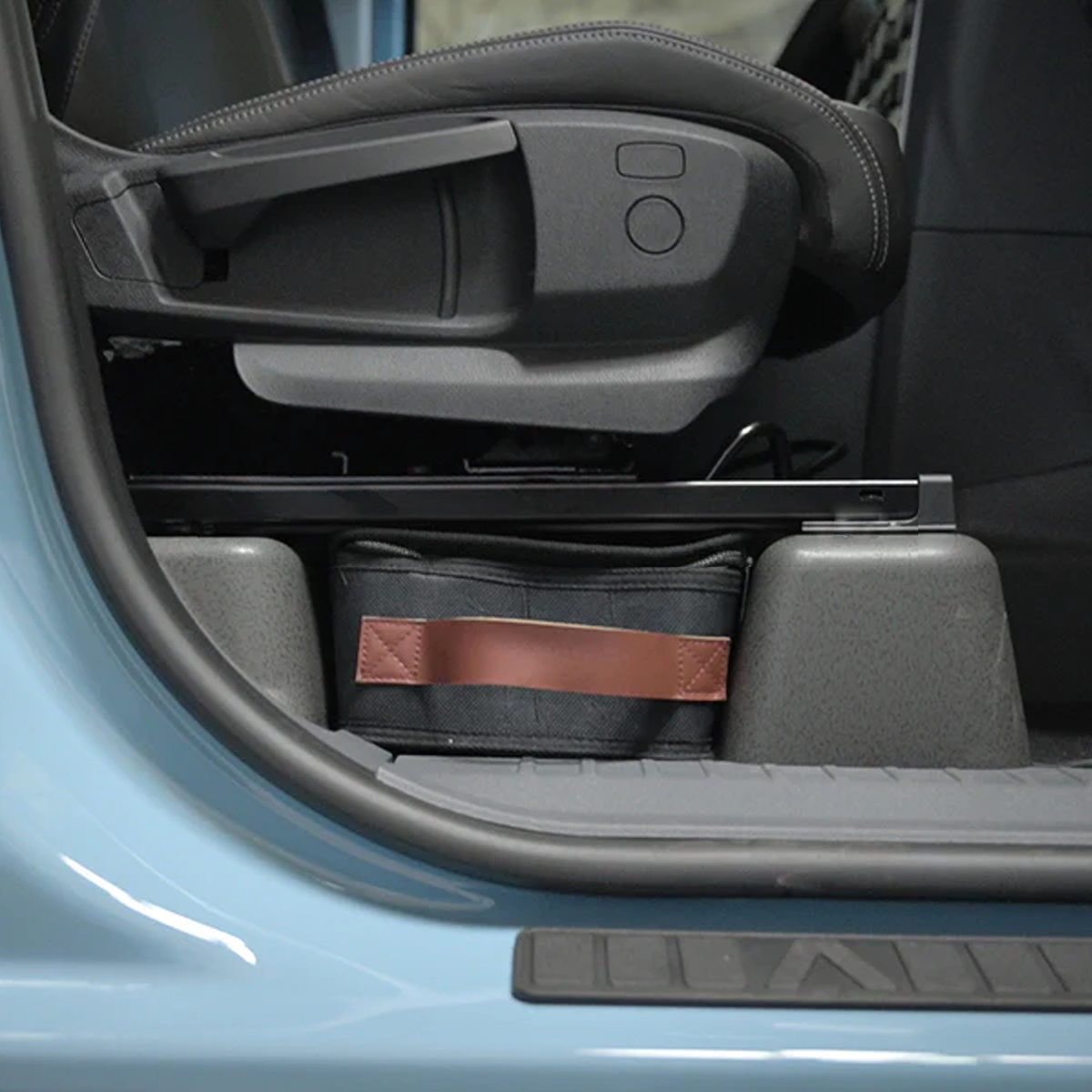 Demonstration of easy access to the INEOS Grenadier under-seat organiser using the handle.