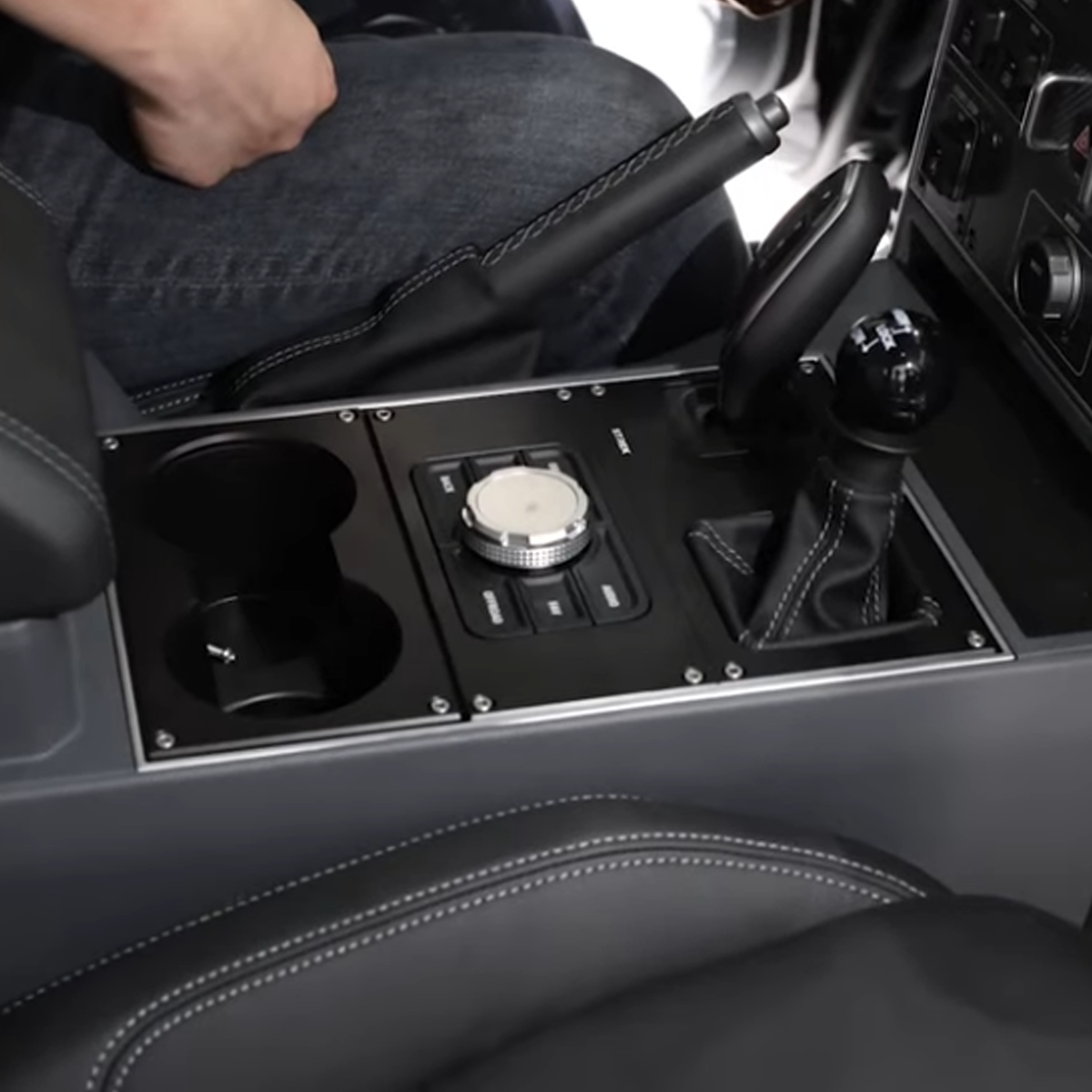 Matte black aluminium cup holder installed in driver side centre console of INEOS Grenadier 2023+