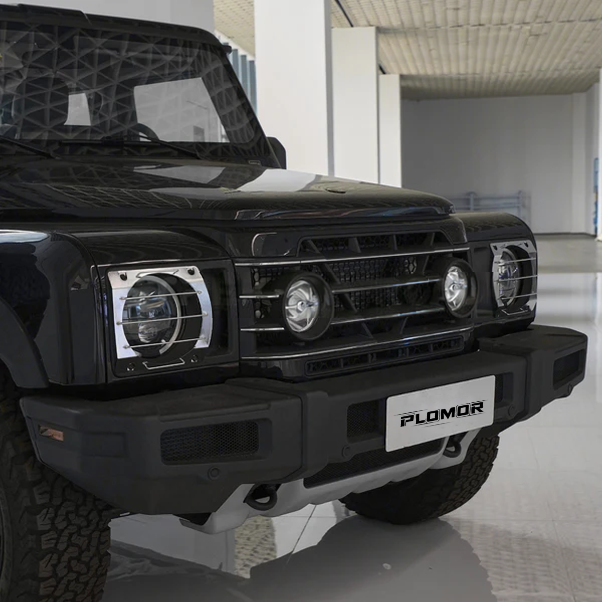 INEOS Grenadier front headlight guards installed, rugged black aluminium protection enhancing front-end styling.