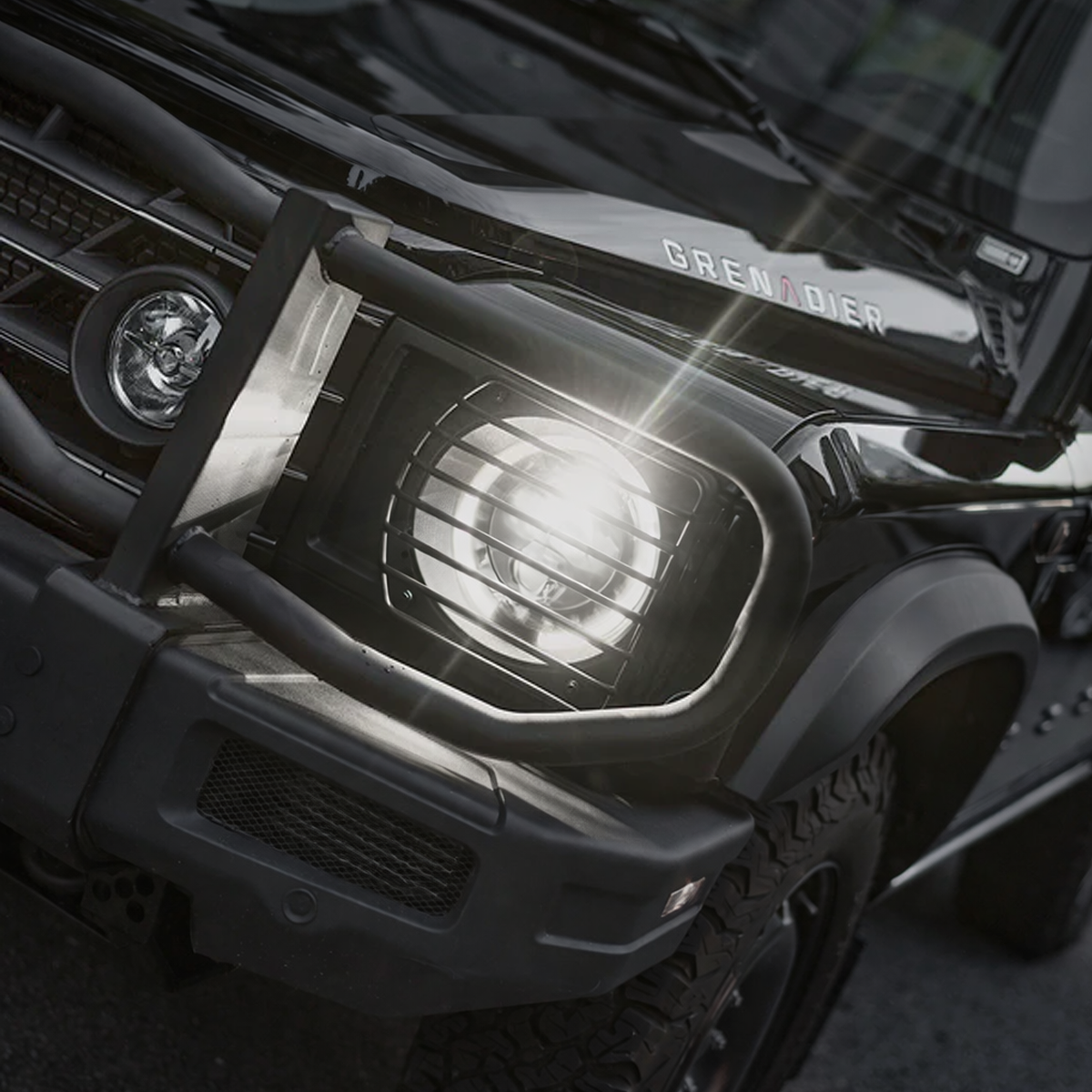 Side view of INEOS Grenadier featuring installed metal headlight guards, protecting headlights from off-road hazards