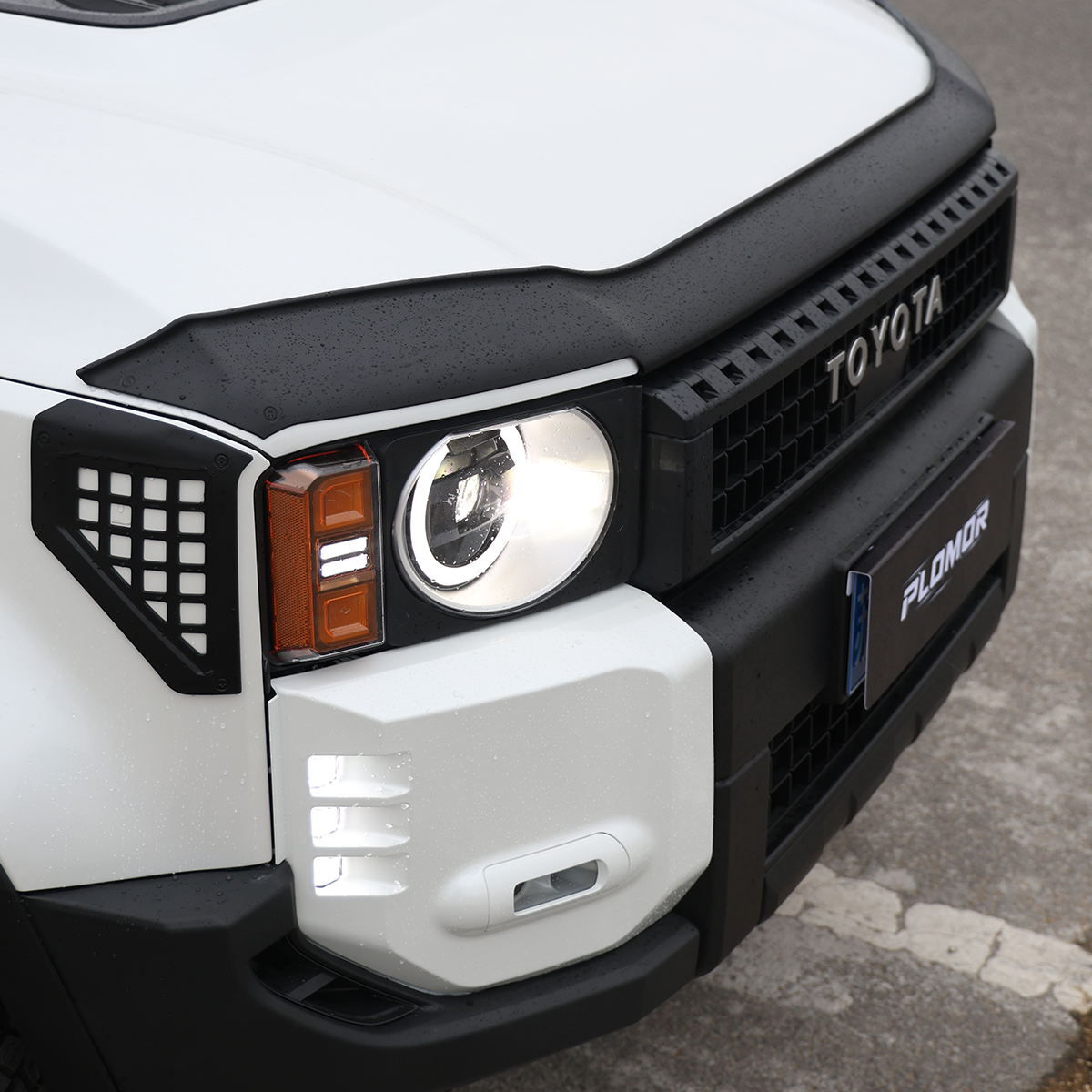 Installed fog light frame on Toyota Land Cruiser LC250 front bumper, maintaining OEM radar sensor clearance