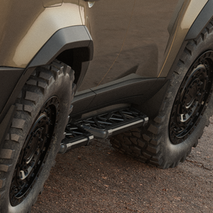 Left side PLOMOR side step installed on LC250 showing open-truss design and bolt-on fit