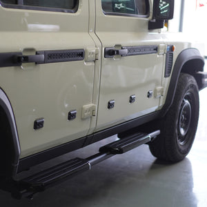 plomor-An image showing the Defender-Style Fixed Side Steps installed on an INEOS Grenadier. The steps feature a flat-platform design with a black powder-coated finish, supported by durable steel brackets and integrated anti-slip pads.