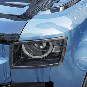Side view of PLOMOR dry carbon headlight covers mounted on Defender 90/110/130