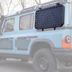 PLOMOR side window armor panel for the INEOS Grenadier with MOLLE grid, powder-coated steel construction, and custom bolt-on fit.