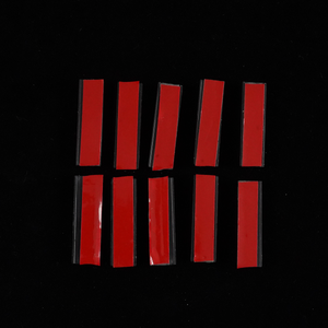 Set of 10 magnetic mounting tabs with 3M automotive tape for skylight sunshade, red release liner visible on each black magnet, laid out on a black background.