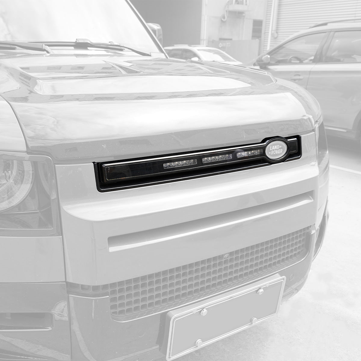 Angled view of PLOMOR LED grille installed on Defender 90