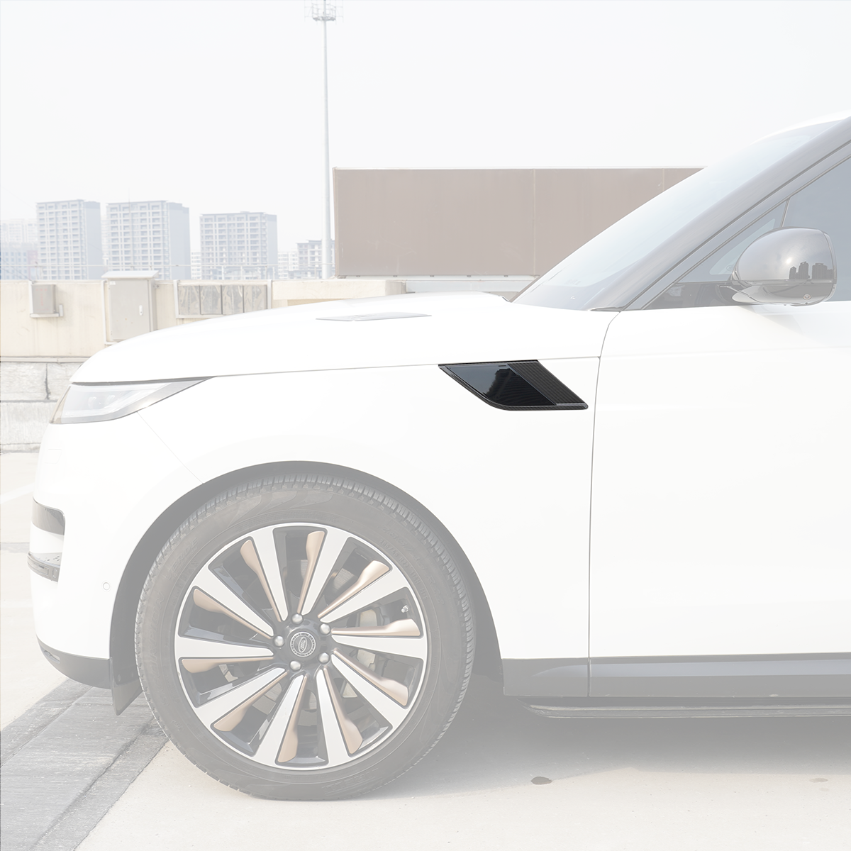 Side view of a Range Rover showing the right-hand fender side vent trim with carbon-fiber look surround and gloss-black insert installed.