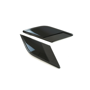 Angled studio photo of a pair of Range Rover fender side vent trim covers with carbon-fiber look surround and gloss-black insert, white background.