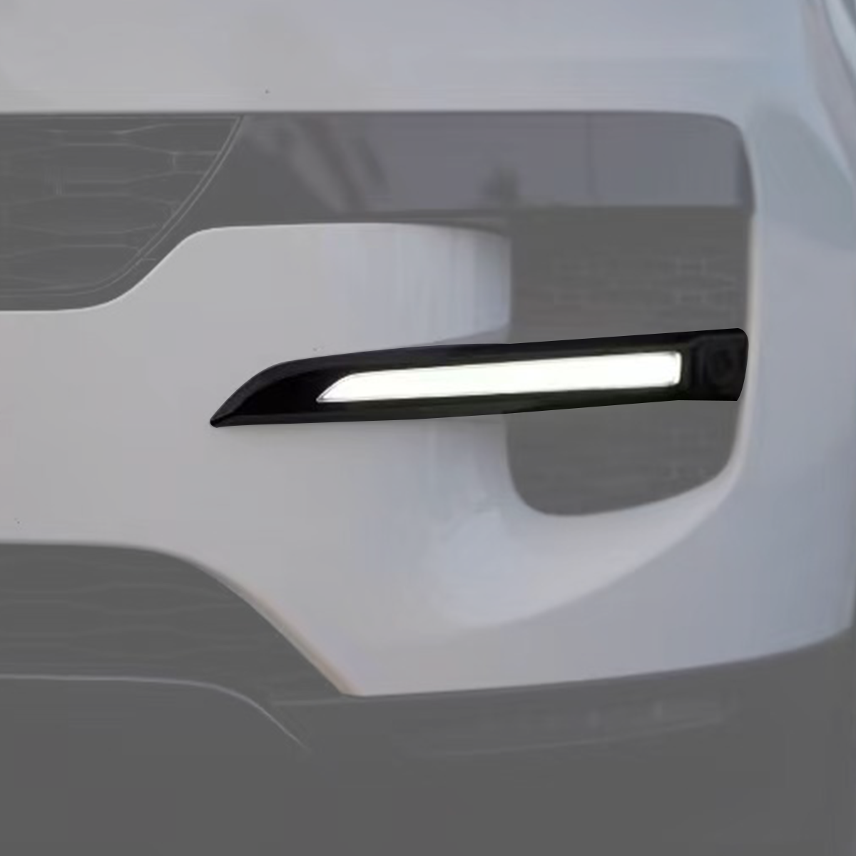 Installed view of a gloss-black side LED light strip on a Range Rover front bumper, illuminated in daytime.