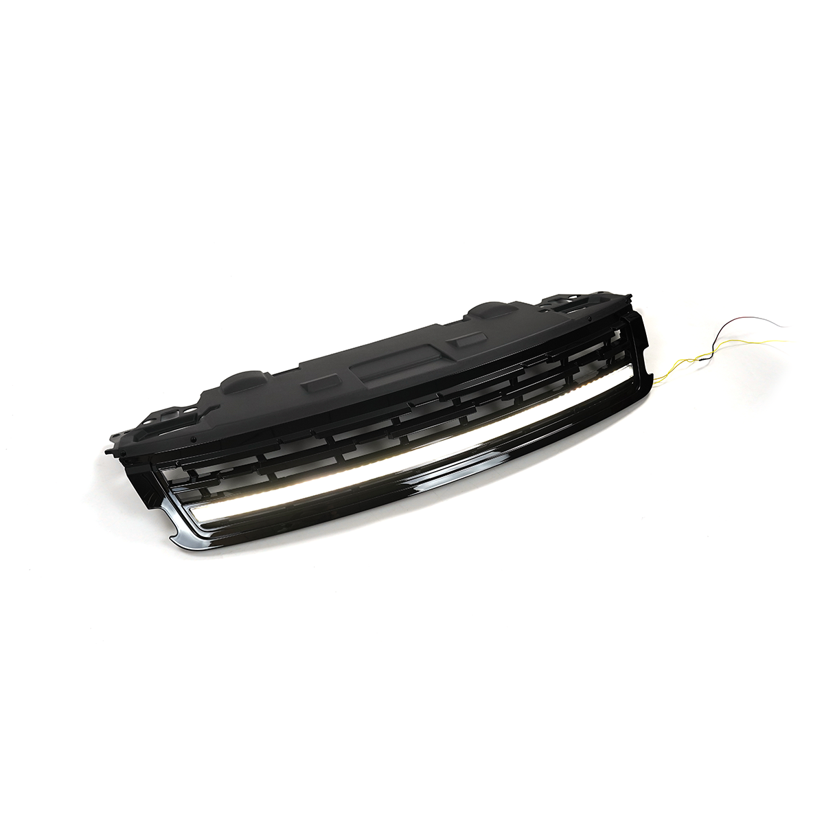 Angled studio shot of a Range Rover front grille assembly with the integrated LED light bar illuminated, gloss-black finish, white background with wiring visible.
