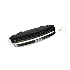Angled studio shot of a Range Rover front grille assembly with the integrated LED light bar illuminated, gloss-black finish, white background with wiring visible.