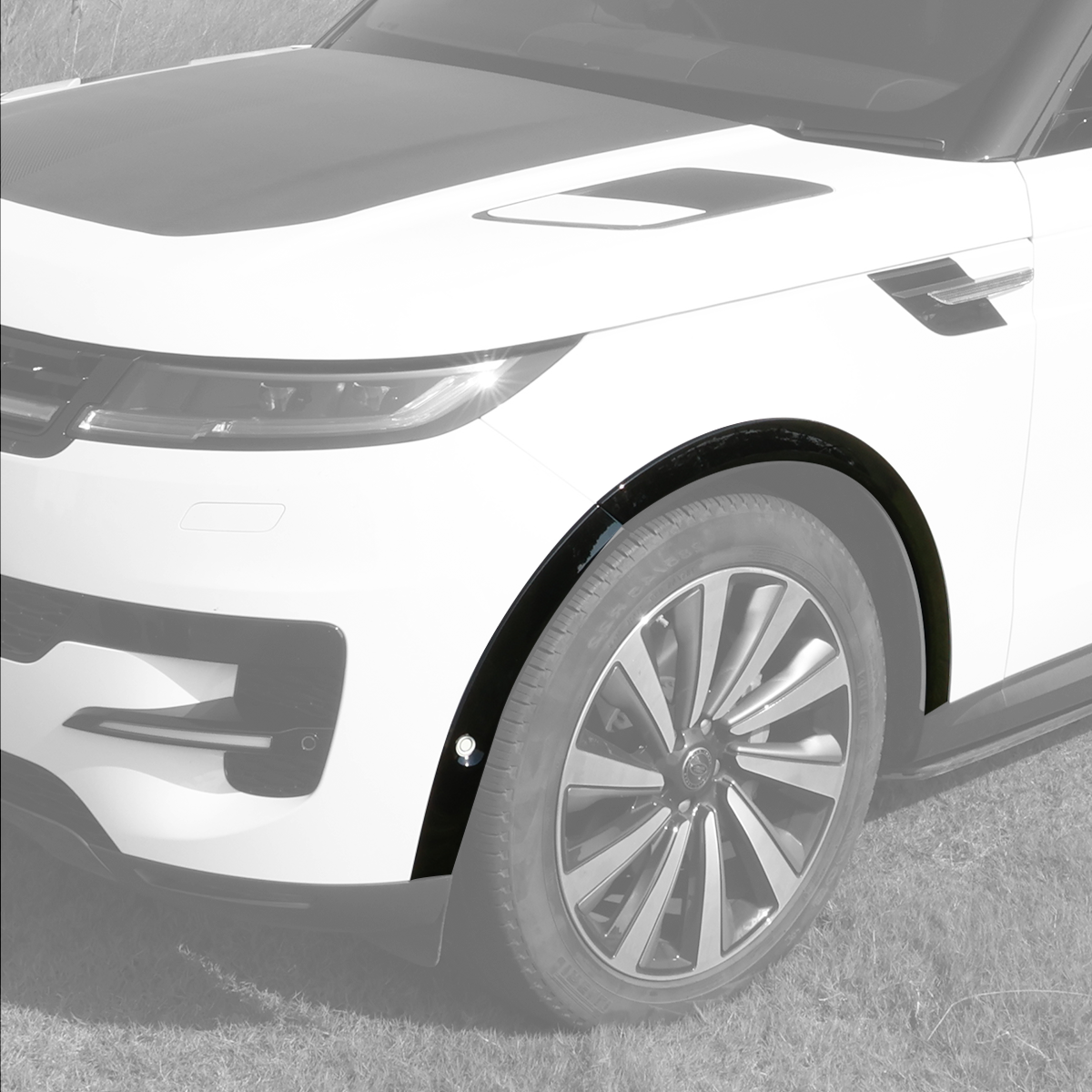 Close-up of PLOMOR gloss-black front-right fender flare installed on Range Rover Sport L461 (2023+), showing OE-style fitment and bolt detail.