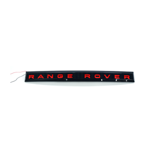 Front view of PLOMOR LED tailgate light bar with illuminated “RANGE ROVER” letters for Range Rover Sport L461 (2023+), red lighting.