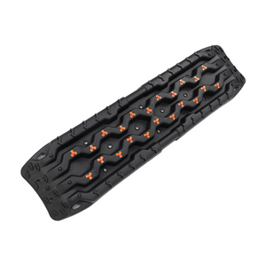 Black off-road recovery traction board with orange cleats, shown in angled three-quarter view on a white background.