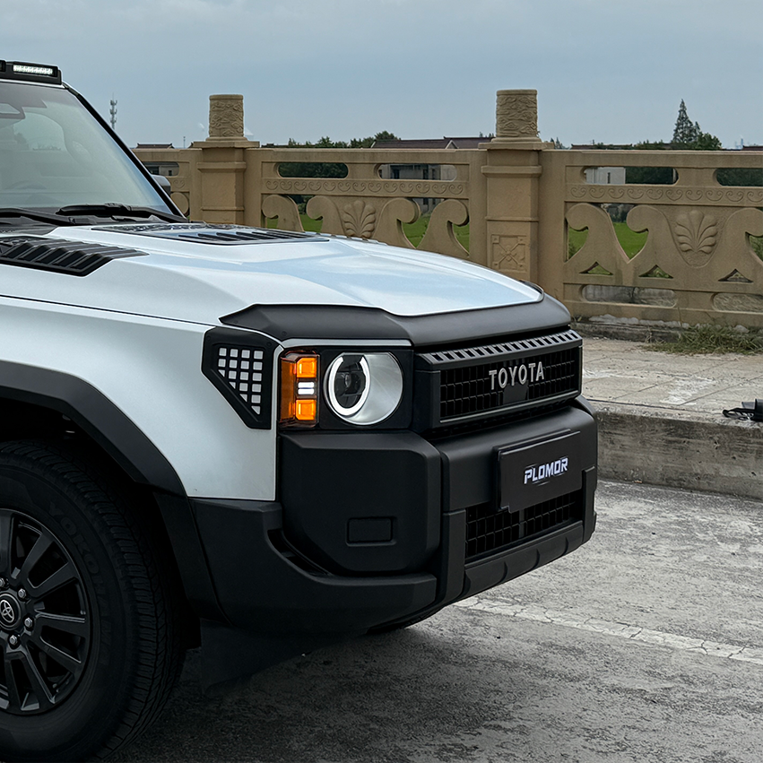 PLOMOR hood deflector on Toyota LC250, bright front-on outdoor installed view