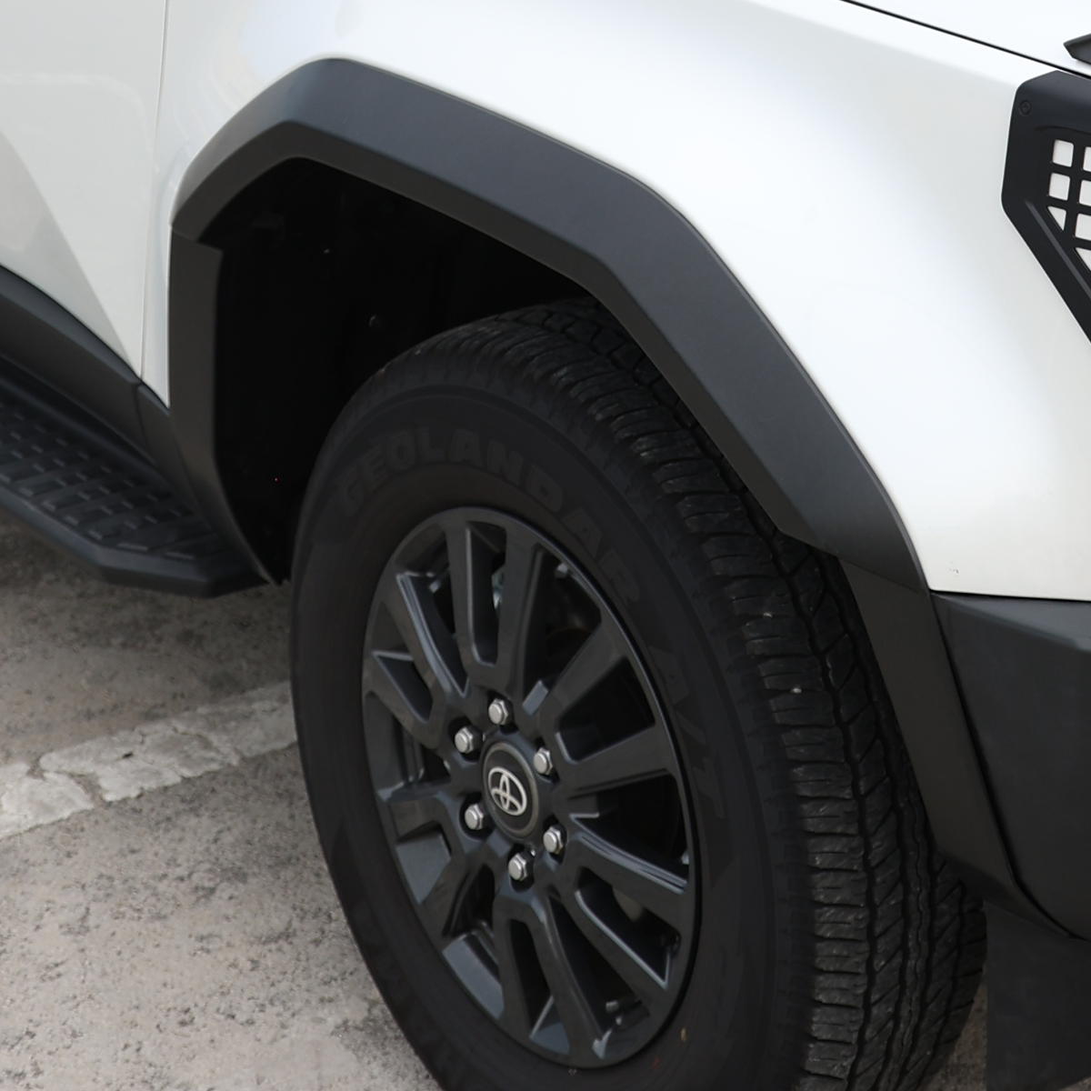 PLOMOR matte black ABS wide body fender flares on Toyota LC250, three-quarter right installed view